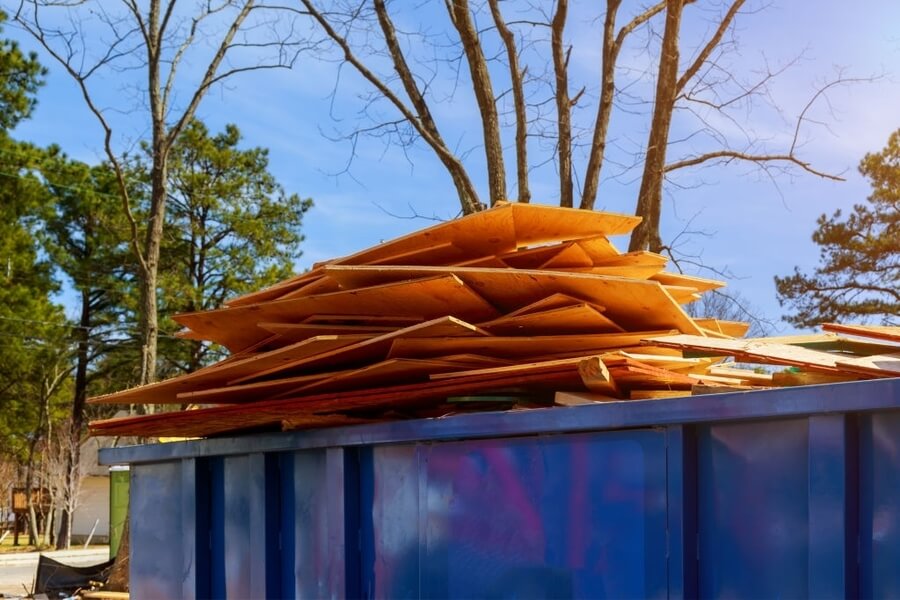 a picture of an flywood debris on the top of an dumpster