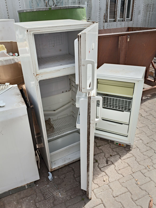 picture of old appliances including an old refrigerator outside a home in amherst, ny